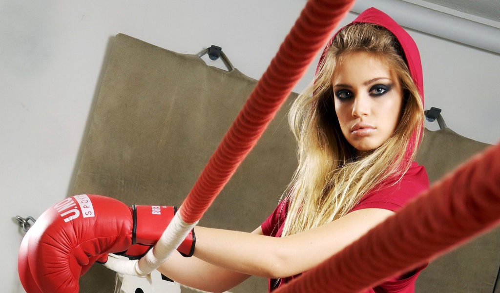 Блондинка в перчатках на боксерском ринге