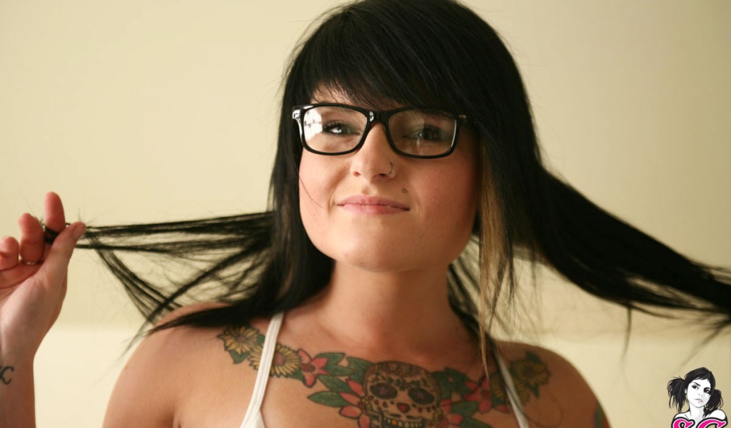 Брюнетка в очках с тату на груди
