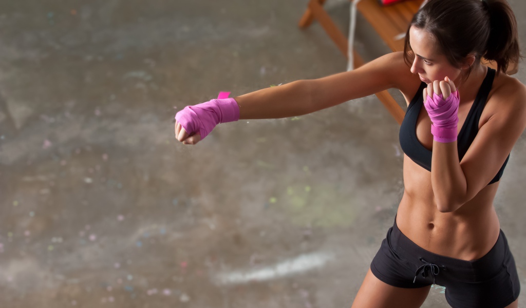 Девушка боксер тренируется в спортзале