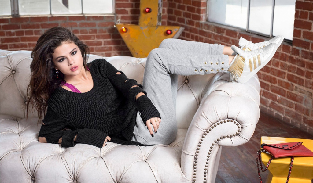 Selena Gomez on a white leather couch