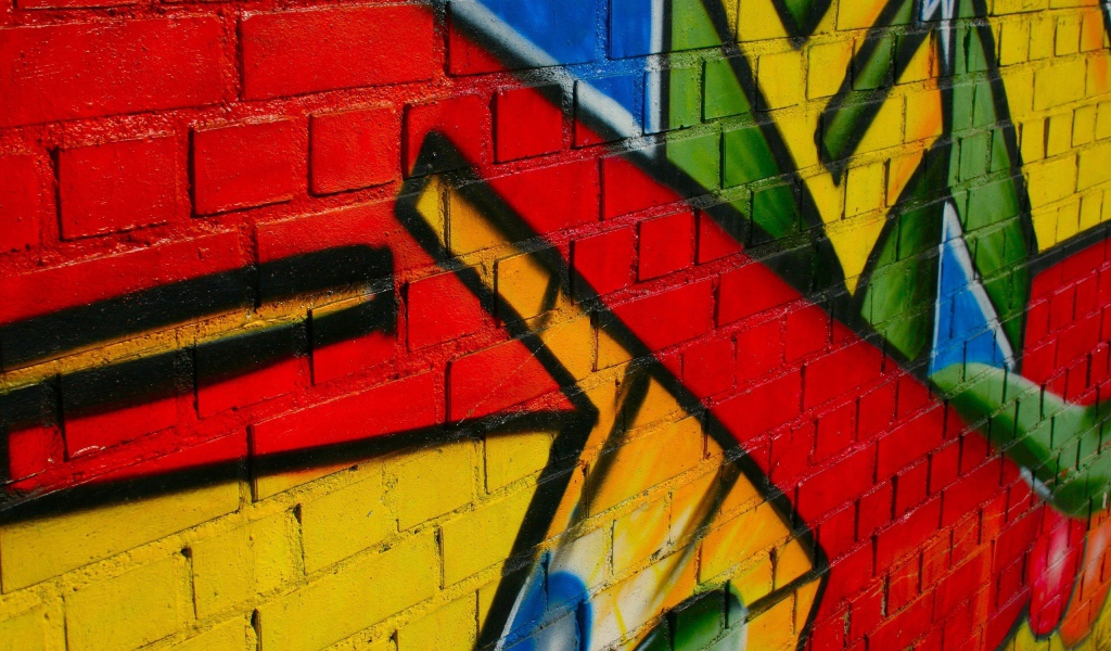 Some of the bright graffiti on a brick wall