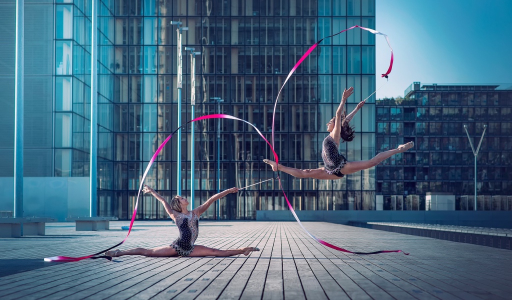 Гимнастки с лентами на площади перед небоскребом