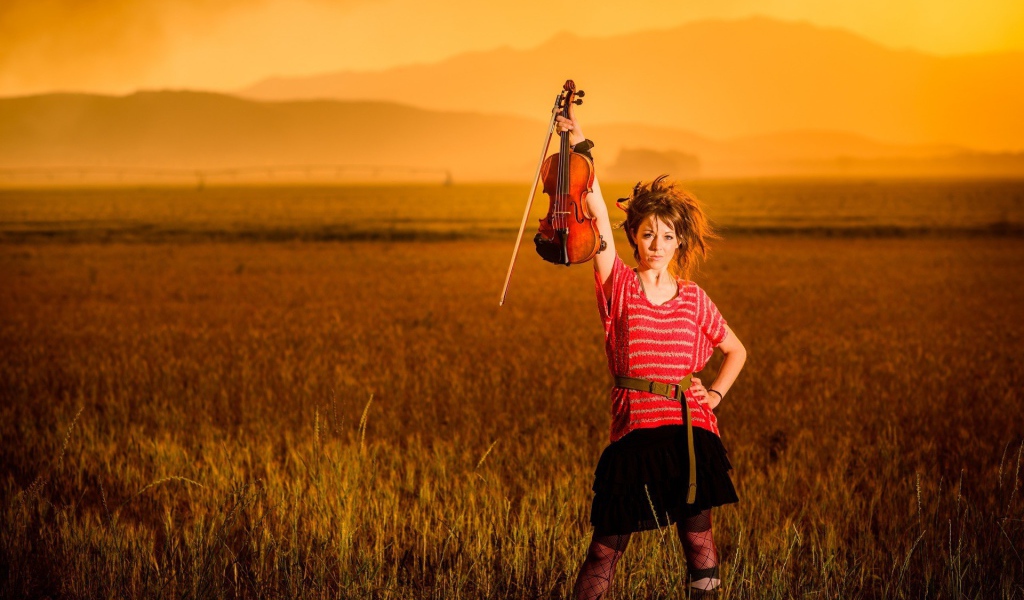 Скрипачка Линдси Стирллинг стоит в поле