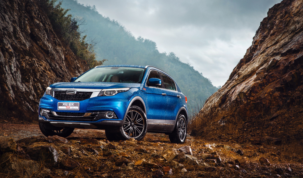 Синий китайский автомобиль Qoros 5  под дождем