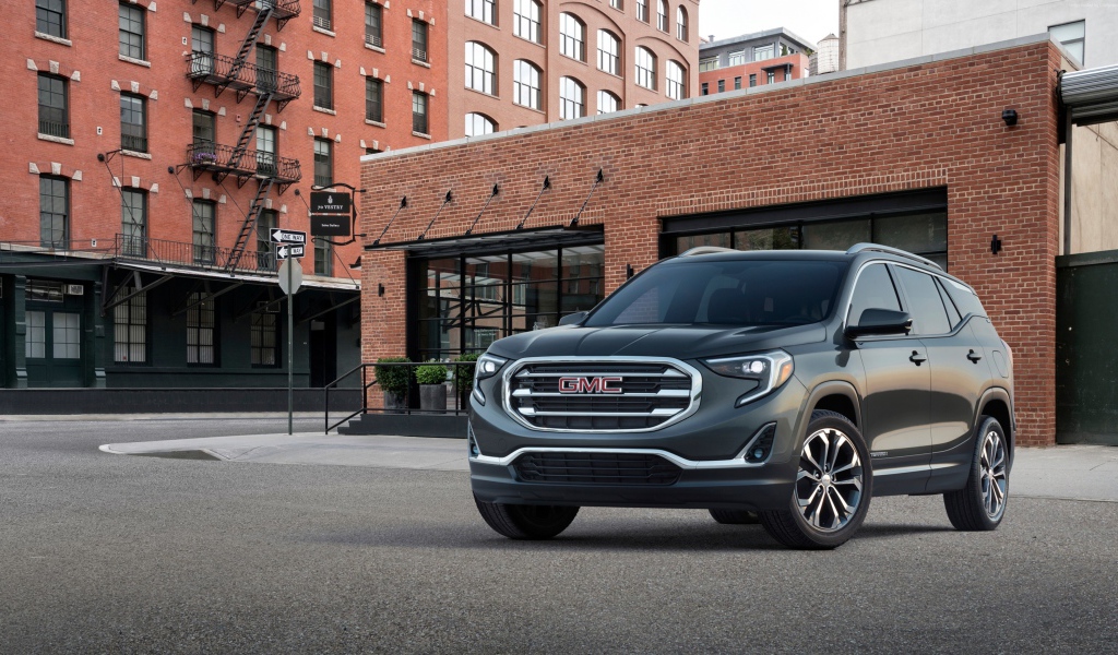 Серый внедорожник GMC Terrain на фоне здания