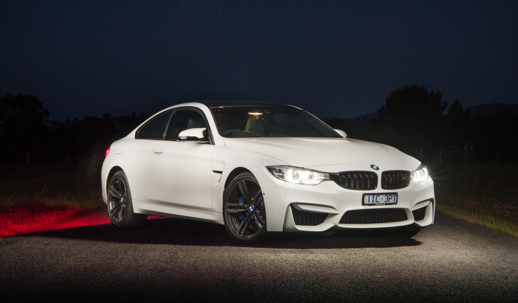 Белый автомобиль BMW M4 Coupe Pure Edition с включенными фарами