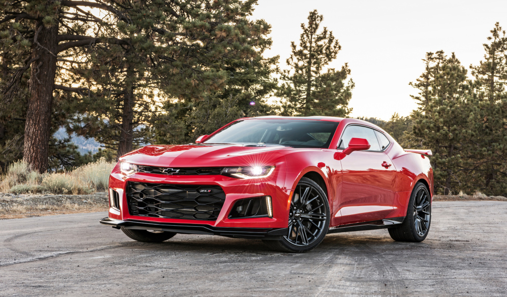 Красный автомобиль Chevrolet Camaro ZL1 на фоне леса 