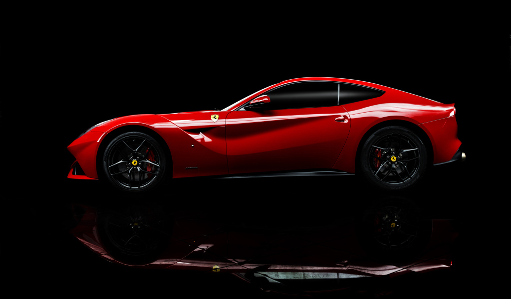 Красный спортивный автомобиль Ferrari F12 berlinetta на черном фоне