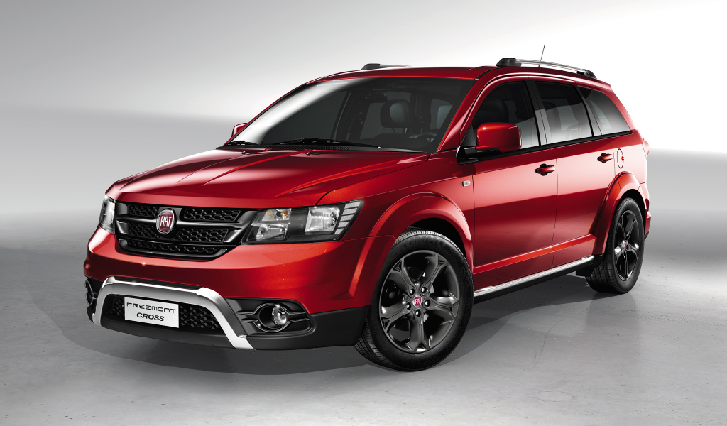 Красный автомобиль внедорожник Fiat Freemont Cross на сером фоне