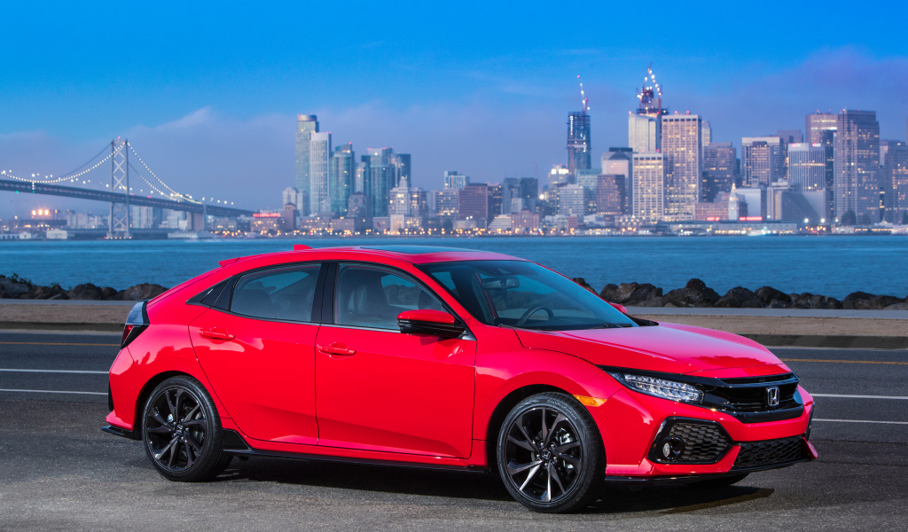 Красный автомобиль Honda Civic Touring Hatchback, 2017 на фоне города 
