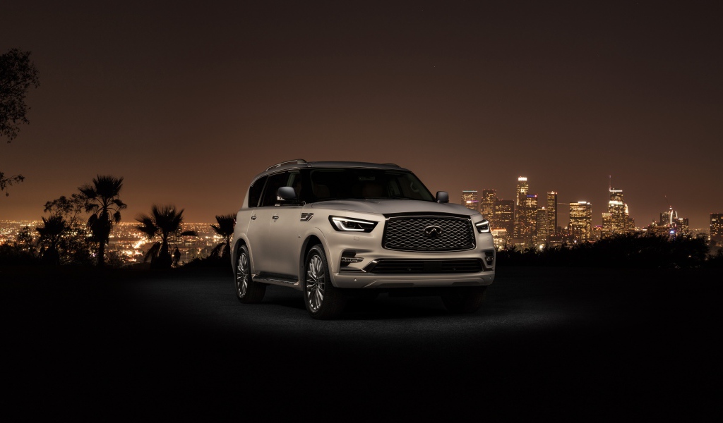 Автомобиль Infiniti QX80 2018 на фоне ночного города