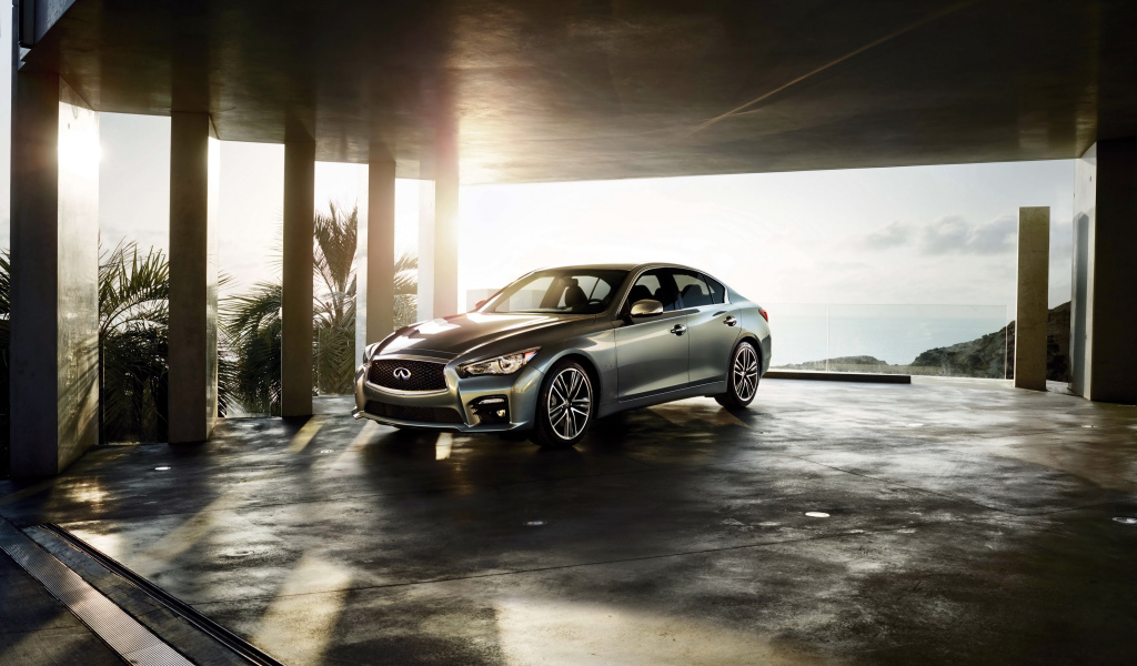 Серебристый автомобиль Infiniti Q50 в лучах солнца 