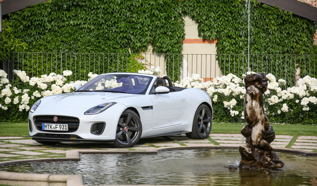 Белый автомобиль кабриолет Jaguar F-Type у фонтана