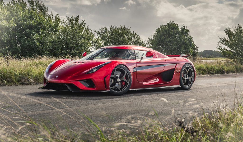 Красный спортивный автомобиль Koenigsegg Regera на дороге