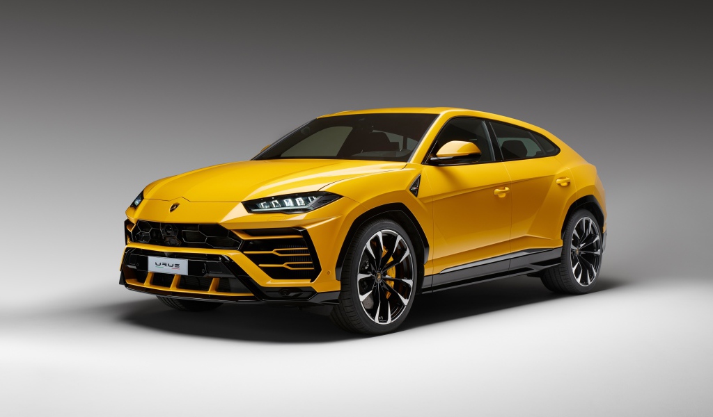 Желтый спортивный автомобиль Lamborghini Urus, 2018 на сером фоне
