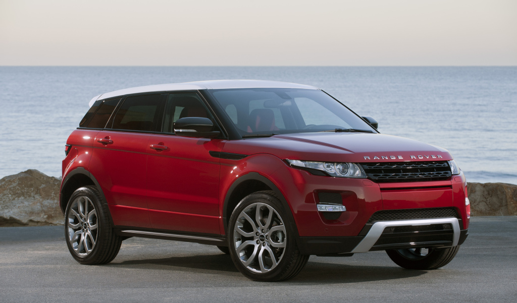 Красный автомобиль Land Rover Caractere на фоне океана