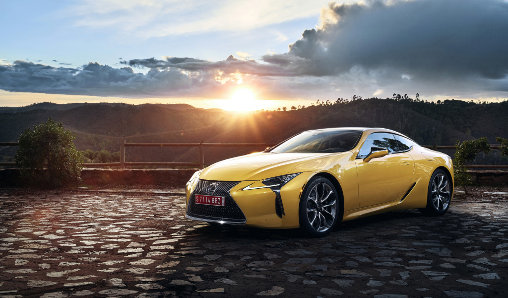 Желтый автомобиль Lexus LC 500  на фоне заката 