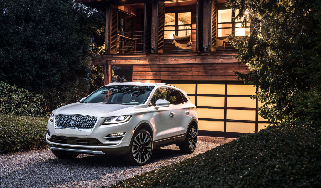 Серебристый автомобиль Lincoln MKC, 2019 у ворот гаража
