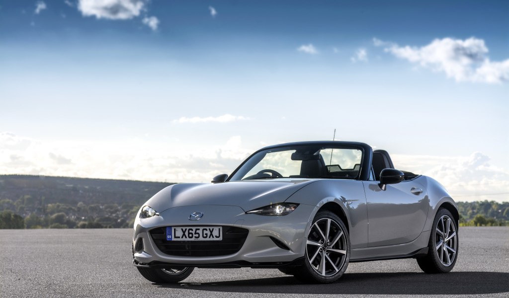 Серебристый кабриолет Mazda MX-5 на фоне красивого неба