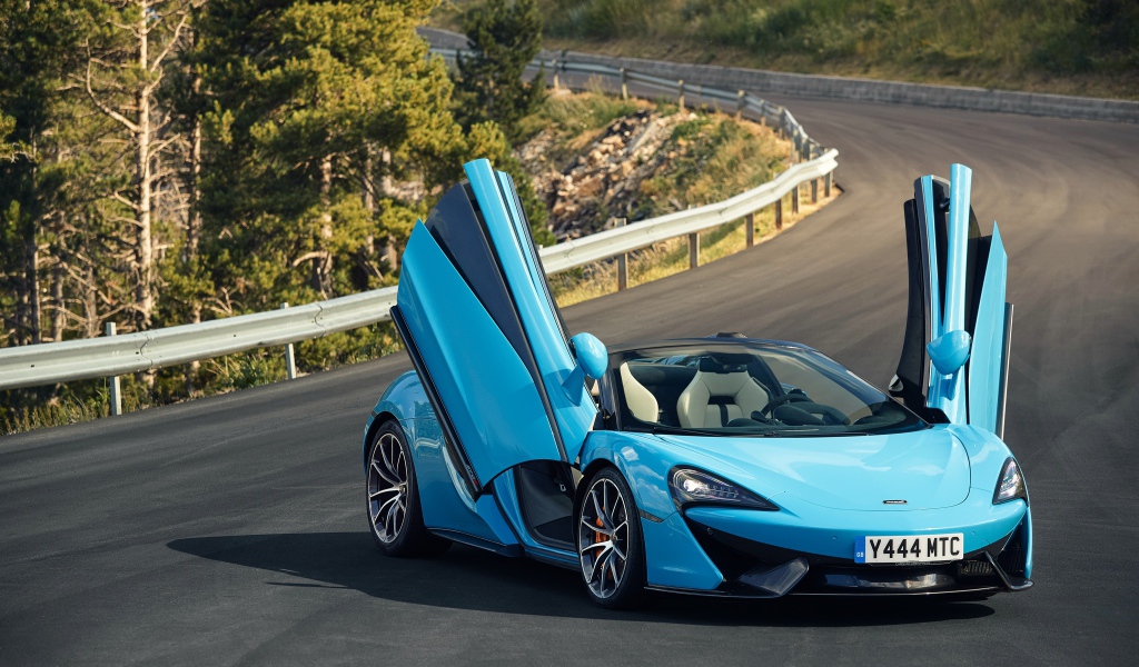 Синий спортивный автомобиль McLaren 570S на трассе с открытыми дверями