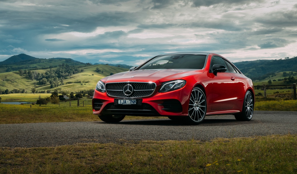 Красный автомобиль Mercedes-Benz E-Class на фоне природы