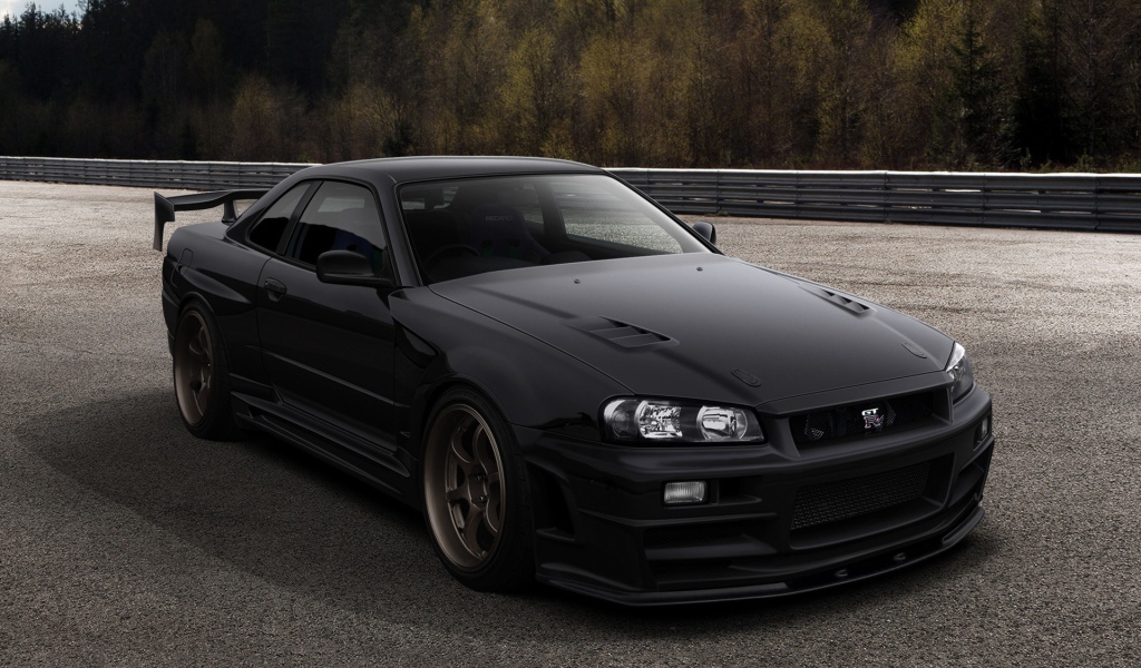 Черный автомобиль Nissan Skyline GT-R R34 на трассе