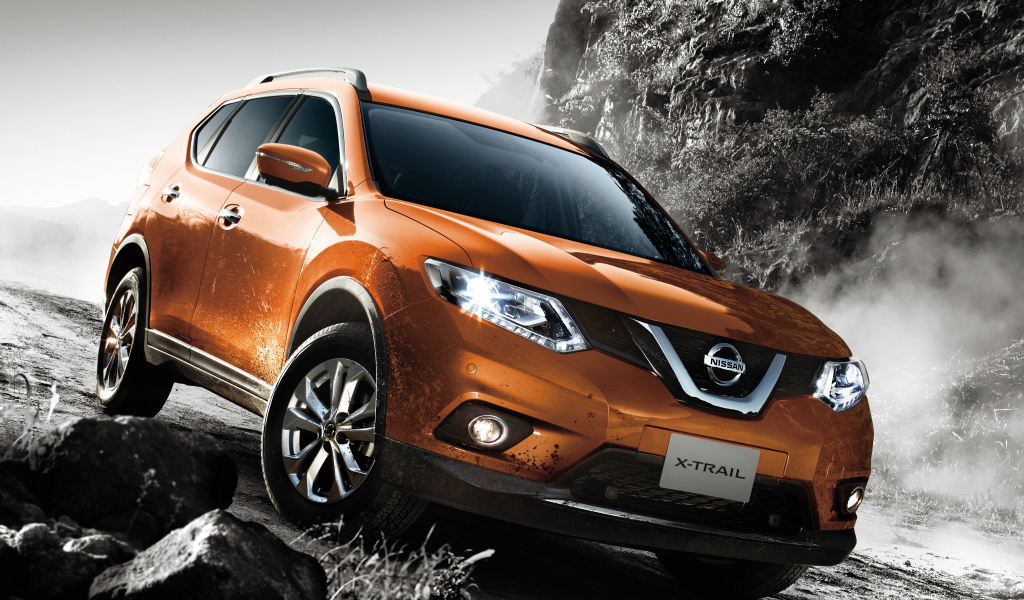 Оранжевый автомобиль Nissan X-Trail на размытой дороге 