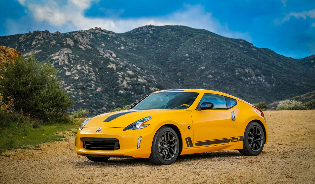 Желтый автомобиль Nissan 370Z Heritage Edition, 2018 на фоне гор