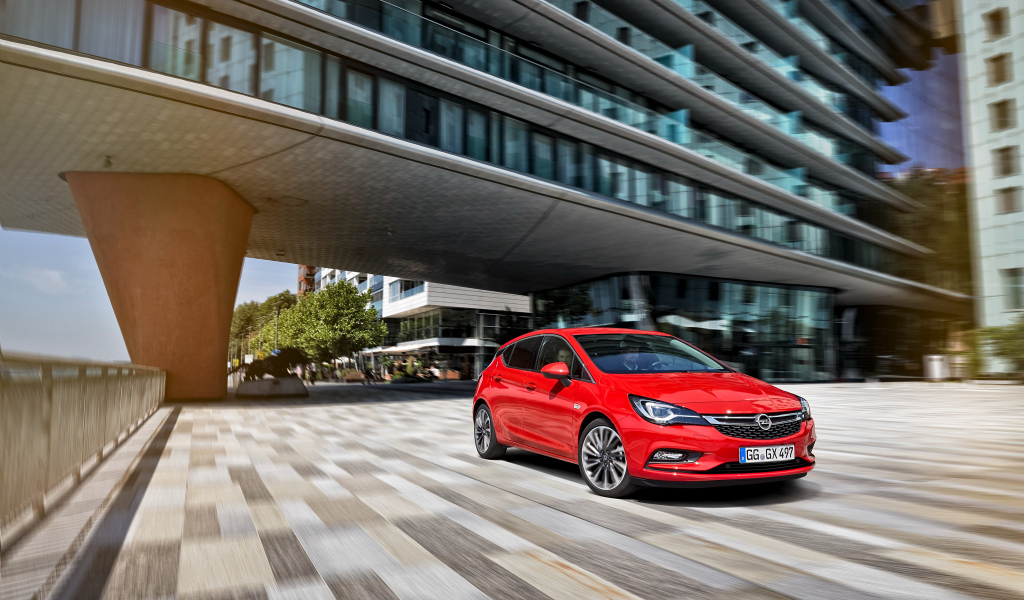 Красный автомобиль Opel Astra в движении