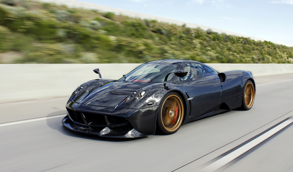 Черный спортивный автомобиль Pagani Huayra на трассе 