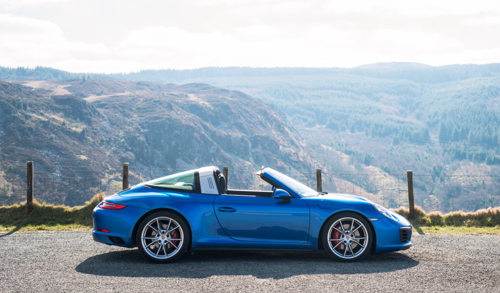Голубой автомобиль кабриолет Porsche 911 Targa 4S на фоне гор