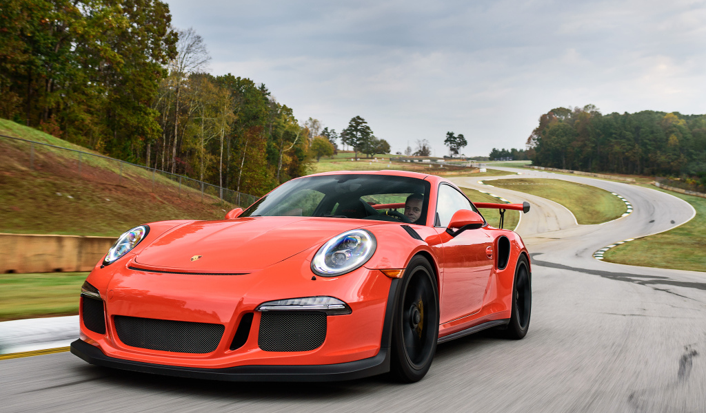 Оранжевый спортивный автомобиль Porsche 911 GT3 на трассе