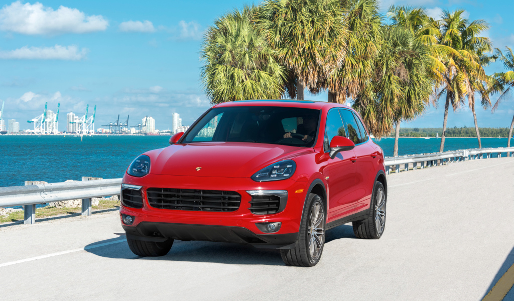 Красный внедорожник Porsche Cayenne на фоне океана
