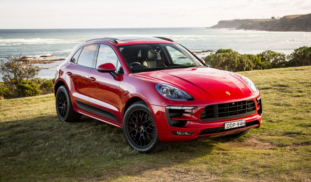 Красный автомобиль Porsche Macan,2017 на фоне океана 
