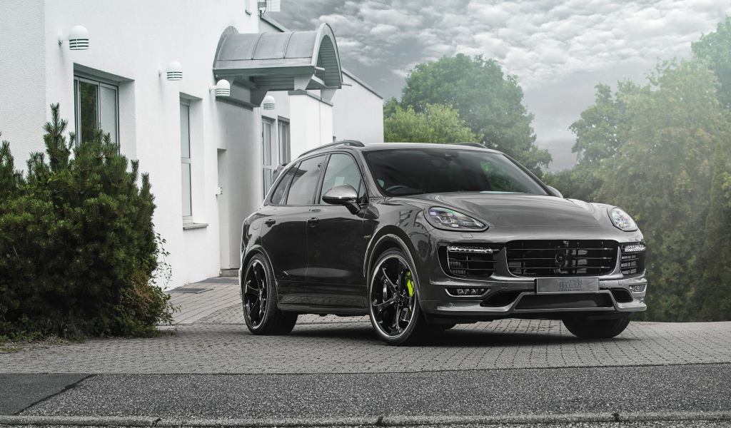 Серебристый автомобиль Porsche Cayenne стоит у дома