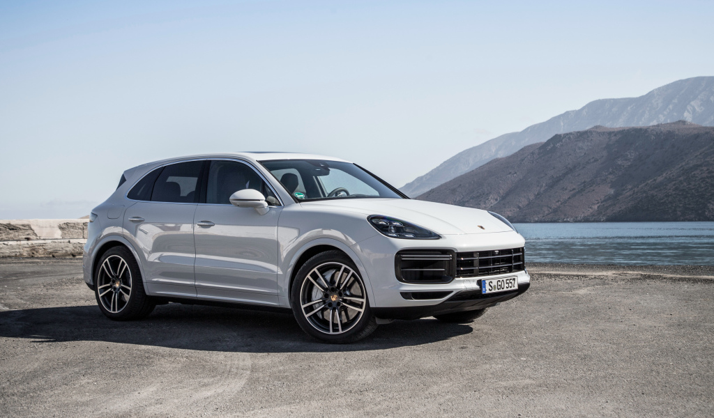 Белый автомобиль Porsche Cayenne Turbo, 2018 у воды