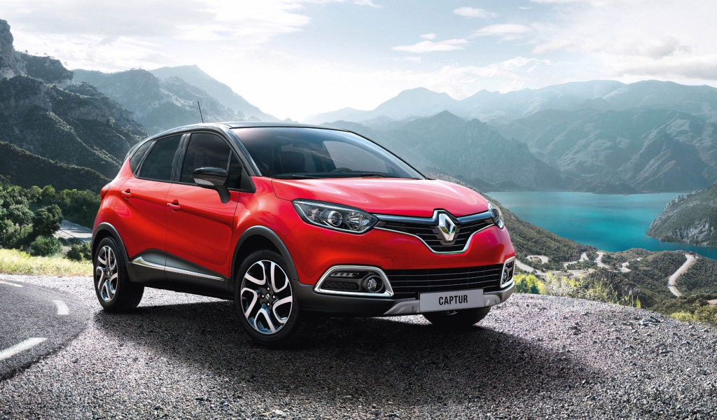 Красный автомобиль внедорожник Renault Captur на фоне гор