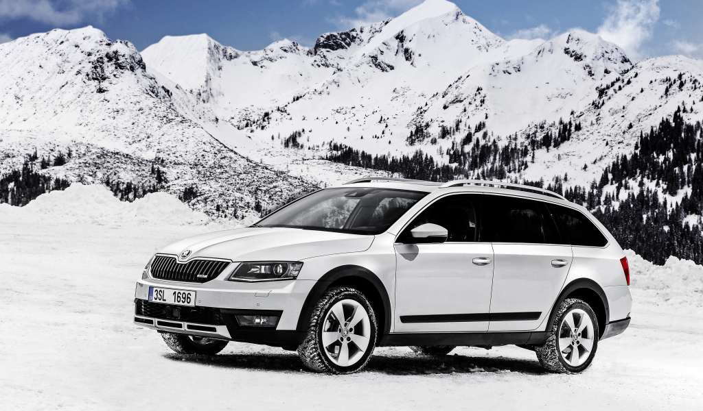 Белый автомобиль Skoda Octavia на фоне заснеженных гор