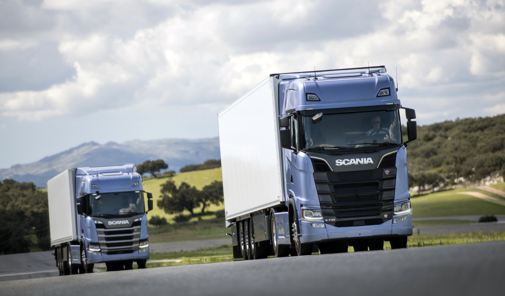 Два голубых грузовика Scania S 700 на трассе