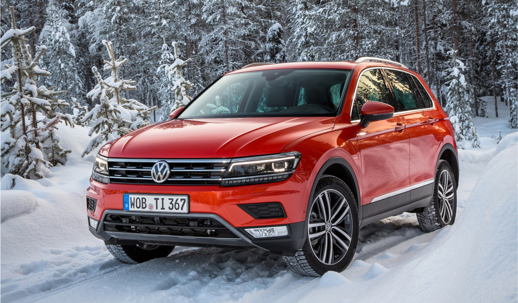 Красный Volkswagen Tiguan 2017 года в заснеженном лесу 