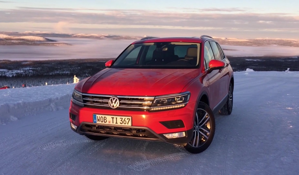 Красный Volkswagen Tiguan 2017 года на заснеженной трассе 
