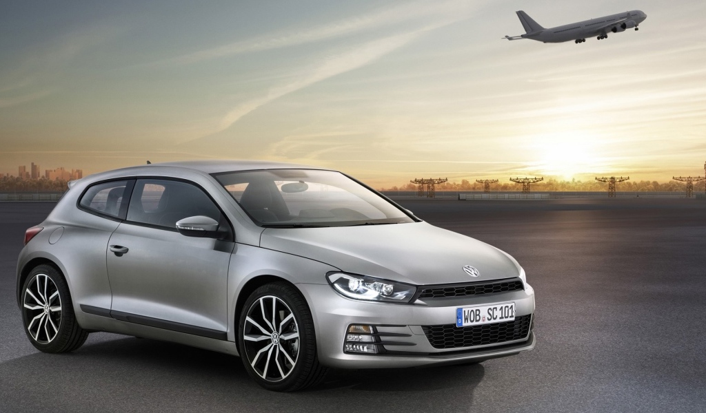 Серебристый Volkswagen Scirocco 2017 года на фоне взлетной полосы 