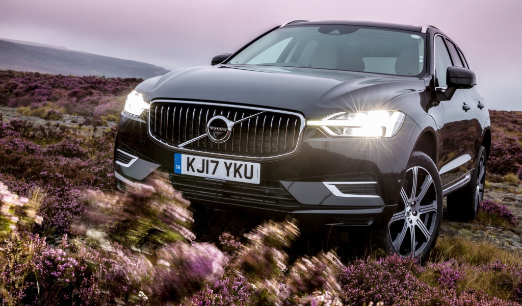 Черный автомобиль Volvo XC60 T8, 2018 с включенными фарами