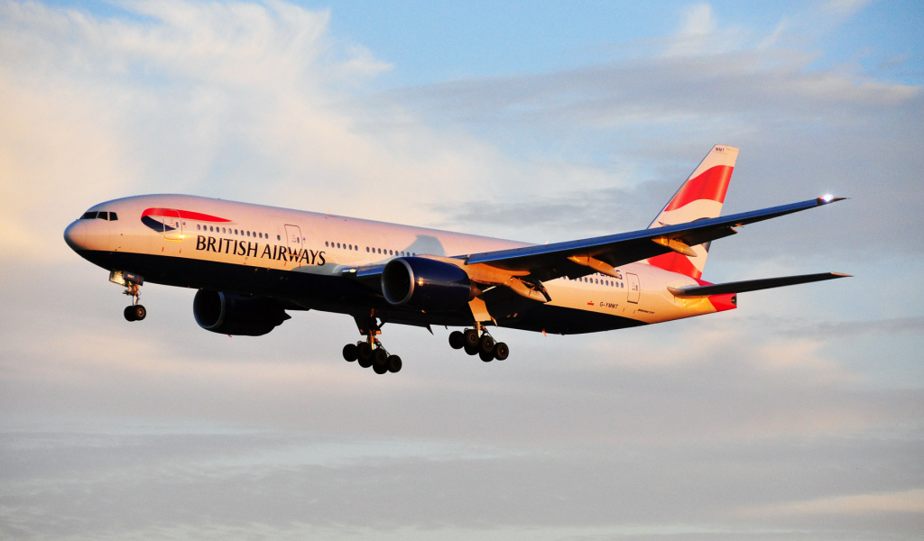 Boeing 777 of British Airways is flying at sunrise