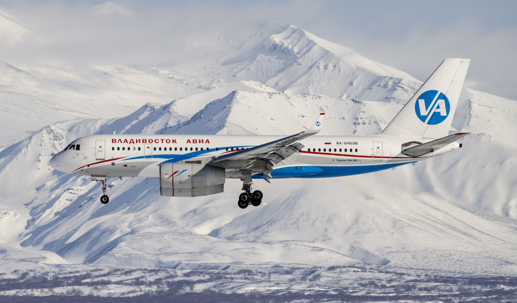 Самолет ТУ 204-300 авиакомпании Владивосток Авиа пролетает над горами Алтая 
