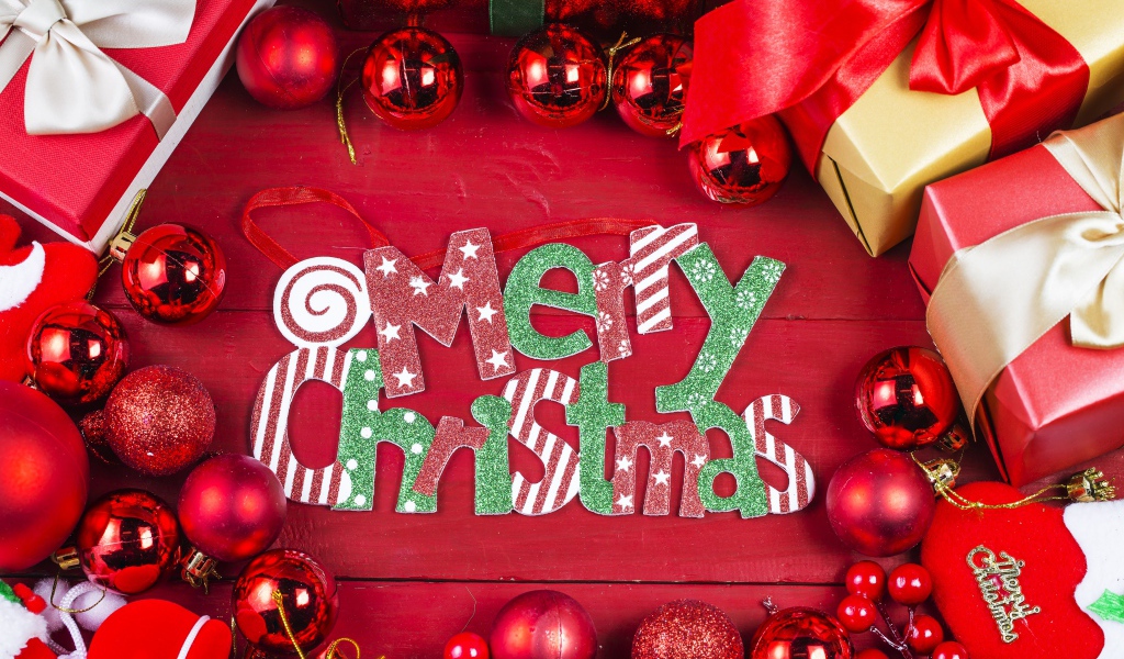 Праздничная надпись Merry Christmas на красном фоне с игрушками и подарками