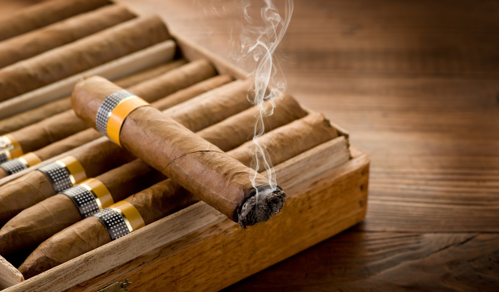 Дымящаяся сигара на столе 