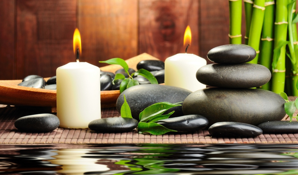 Черные камни дзен с двумя горящими свечами