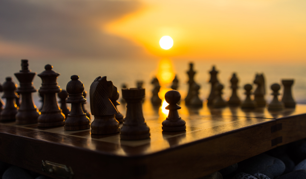 Шахматная доска с шахматными фигурами на закате солнца