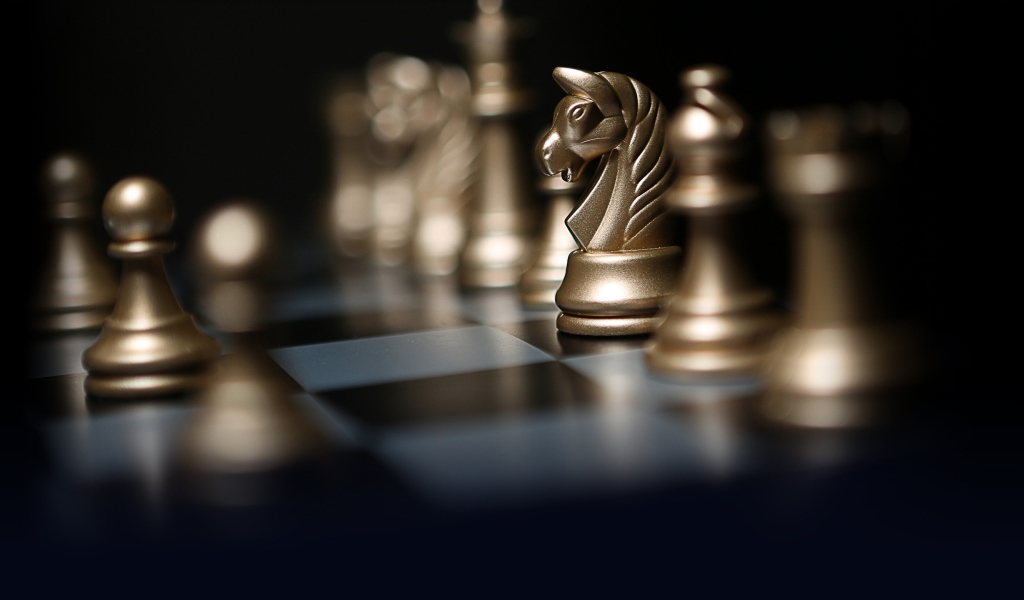 Золотые шахматные фигуры на шахматной доске